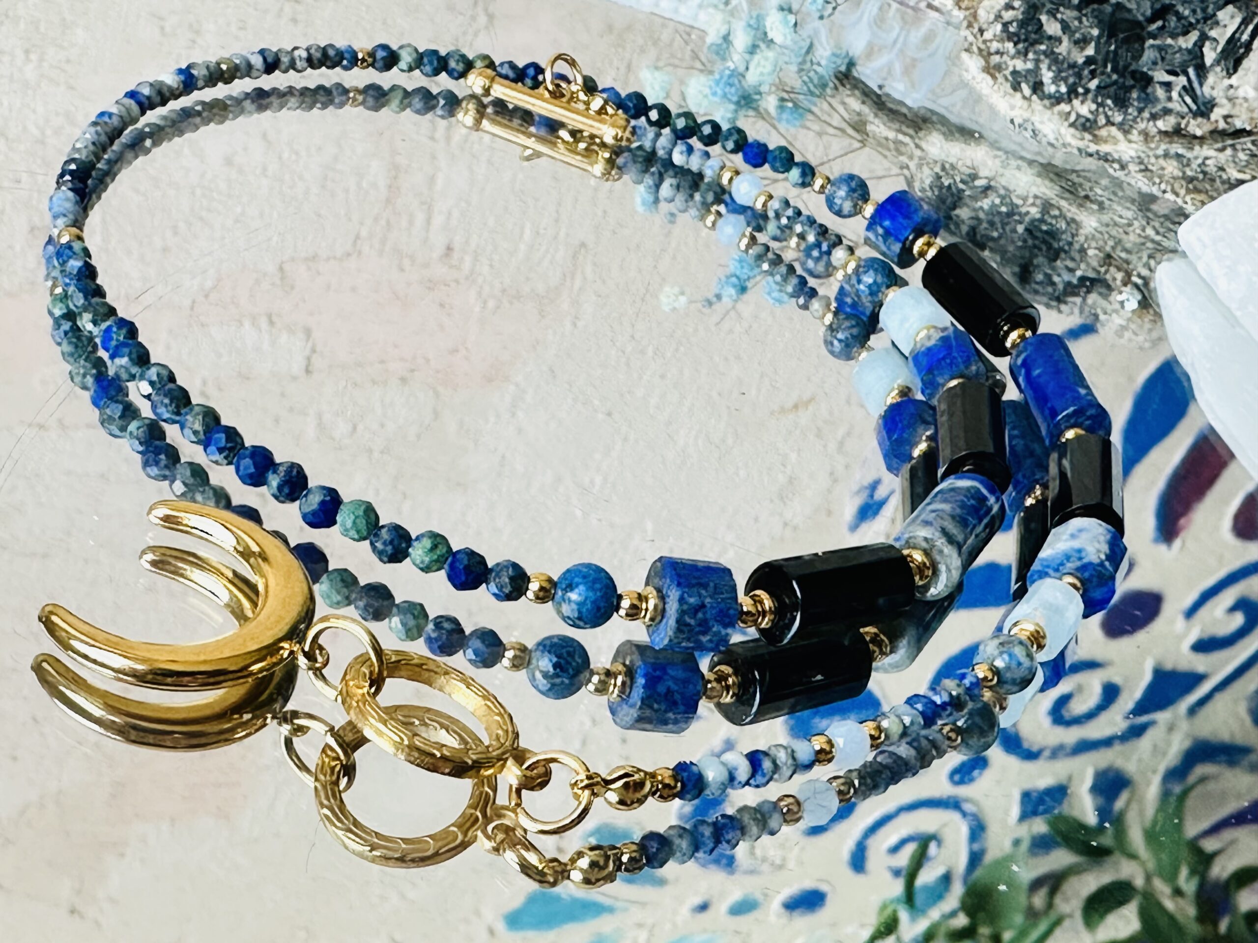 Elegancki naszyjnik „Nadiré” z Lapis Lazuli, akwamarynem, czarnym agatem i azurytem na złotej lince ze stali nierdzewnej z zawieszką księżyca.
